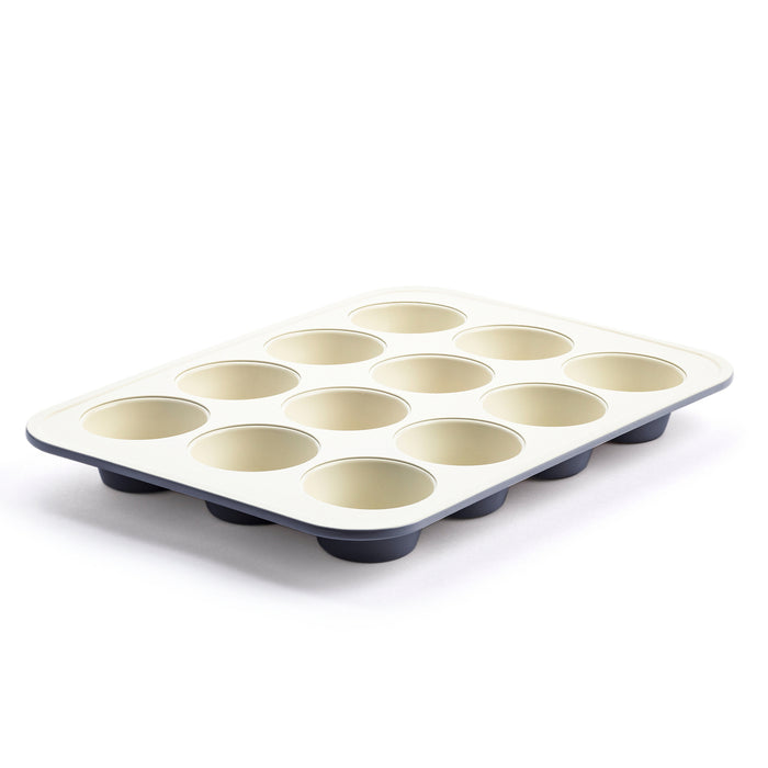 Black ceramic 12-cup muffin pan shown at an angle on a white background.