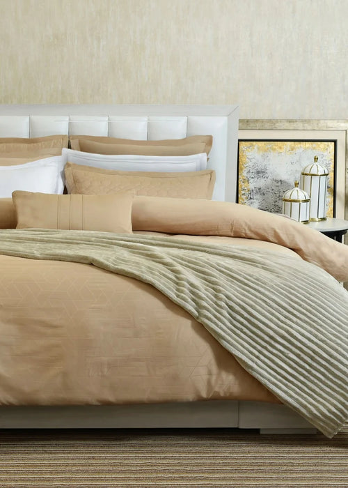 Butter cotton sateen duvet cover set on bed with pillow shams and striped bed sheet