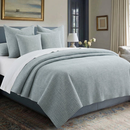 Pick-Stitch Artisan Square Pillow on a cozy bed with matching quilt and decorative pillows, showcasing artisan texture.