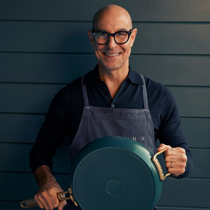Man in glasses and apron holding an 8-inch Venetian Teal Stanley Tucci ceramic frypan.