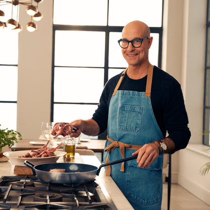 Man cooking meat in a stainless steel ceramic nonstick frypan in a modern kitchen.