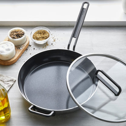 12-inch stainless steel ceramic nonstick frypan with lid on countertop, near spices and olive oil.