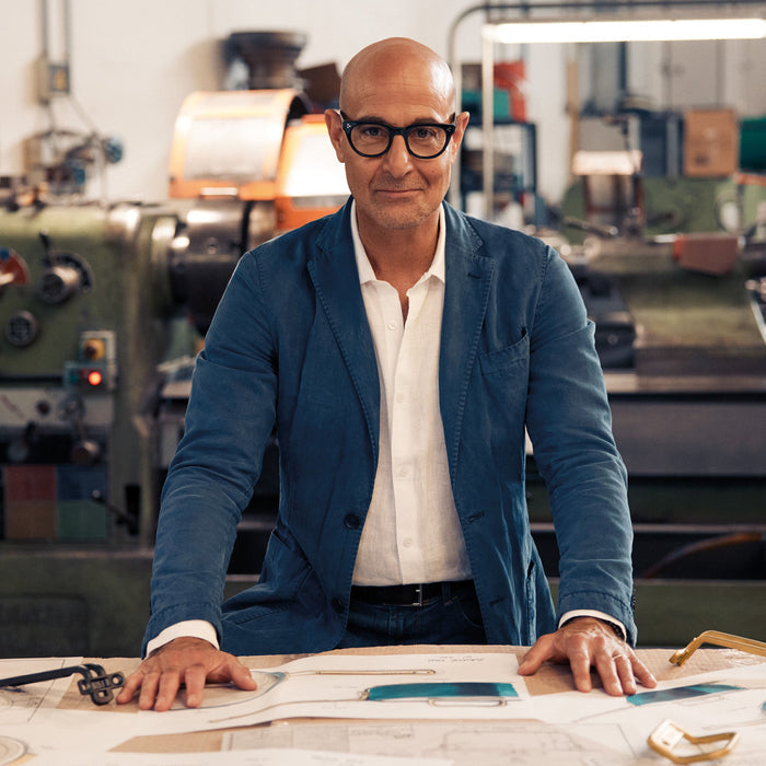 A man in glasses and a blue blazer stands beside a stainless steel 4-quart sauté pan with lid.